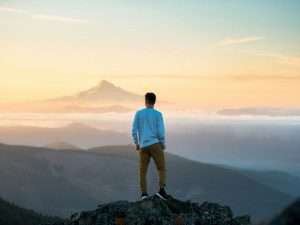 man standing on top of mountain