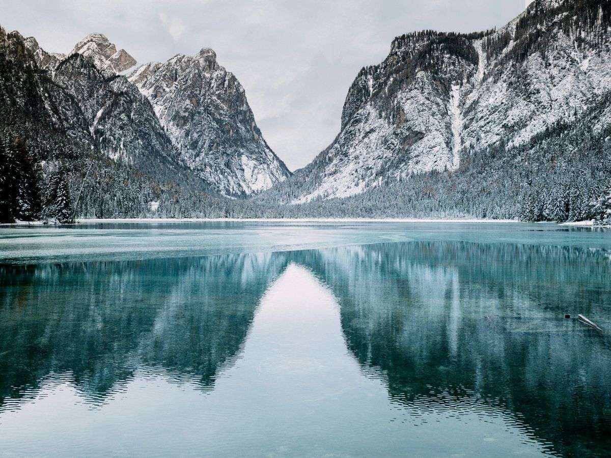 Body Of Water And Snow-Covered Mountains During Daytime
